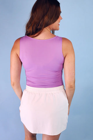 Lavender v-neck bodysuit with a fitted silhouette, double-lined front for coverage, and snap closure, styled for everyday layering and casual outfits.