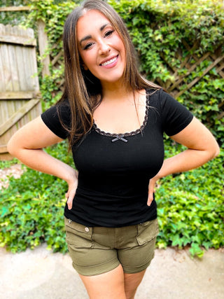 Woman wearing the Lace Trim Ribbed Tee, styled casually with jeans for a chic, feminine look.