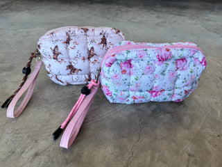 Small quilted puffer clutch with zipper closure and clip-on strap, designed to hold essentials like phone, keys, and cards — lightweight and sporty for everyday use.