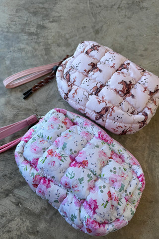 Small quilted puffer clutch with zipper closure and clip-on strap, designed to hold essentials like phone, keys, and cards — lightweight and sporty for everyday use.