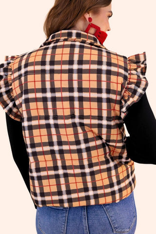 Woman wearing the Nora Plaid Puffer Vest layered over a cozy sweater for a chic, winter-ready look.