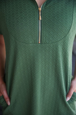 Olive green textured zipper dress with pockets, featuring a modern zip detail and flattering silhouette; styled as a chic fall wardrobe essential.