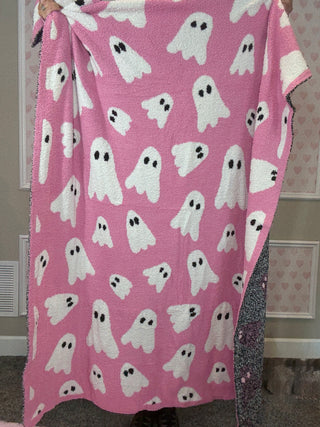 Pink blanket with white ghost pattern held by a person