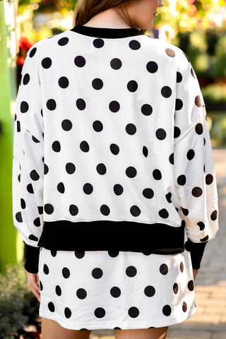 White dress with black polka dots worn by a person outdoors