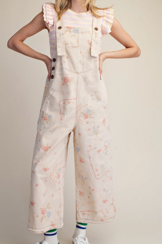 Wearing a floral patterned overalls on a plain background