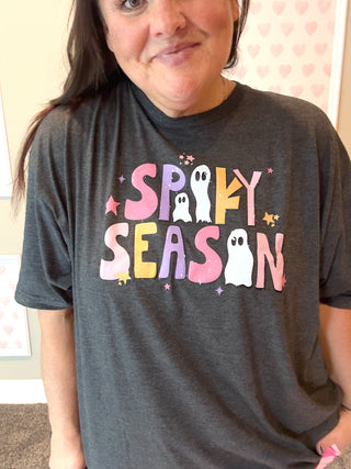Person wearing a dark gray t-shirt with 'Spooky Season' text and ghost graphics.