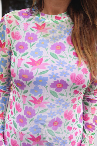Close-up of Spring Meadow Mesh Top showing vibrant spring floral print on stretchy sheer mesh fabric with feminine lettuce hem sleeve detail.