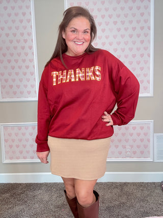 Burgundy long-sleeve pullover with plaid patch and embroidered edges — soft, stretchy fabric perfect for cozy fall outfits.