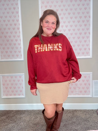 Burgundy long-sleeve pullover with plaid patch and embroidered edges — soft, stretchy fabric perfect for cozy fall outfits.