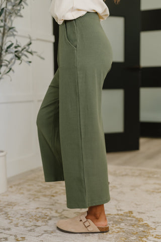 Person wearing green pants with a blurred background