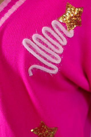 Hot pink relaxed-fit cardigan with light pink accents, decorated with colorful tinsel Christmas trees topped with sparkling stars.