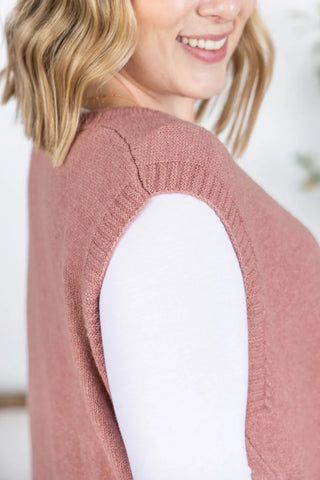 Close-up of the soft ribbed knit texture and pocket detail on the rose sweater vest.