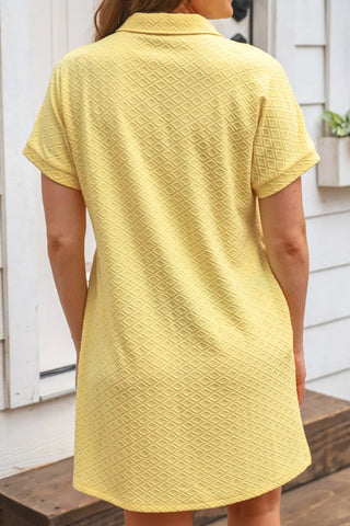 Full-length view of butter yellow A-line dress with textured fabric and zipper neckline, styled with sandals for effortless comfy mom style look.