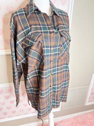 Oversized brown plaid flannel shirt with teal and cream accents button front and relaxed fit for cozy fall layering