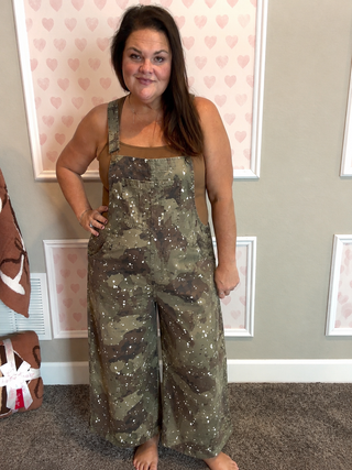 Women's 100% cotton camo overalls with adjustable straps and wide-leg fit.