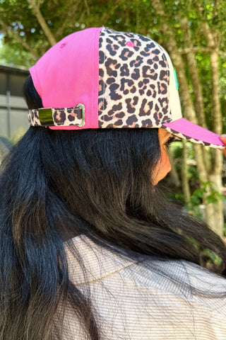 Pink, cream, and leopard color block hat with multicolor pastel puff embroidered "Dream Big" lettering and adjustable metal closure.