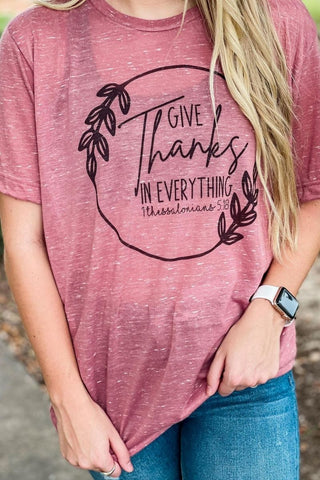 Person wearing a pink t-shirt with 'Give Thanks in Everything' text