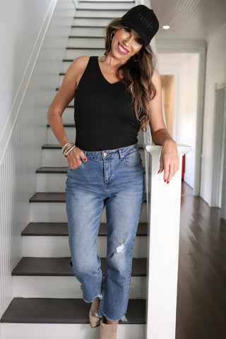 Woman wearing the Haven V-Neck Bodysuit, styled with jeans for a chic, versatile look.