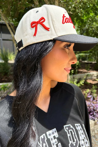 Cream and black game day hat with embroidered "Not My First Tailgate" lettering and embroidered bow detail.