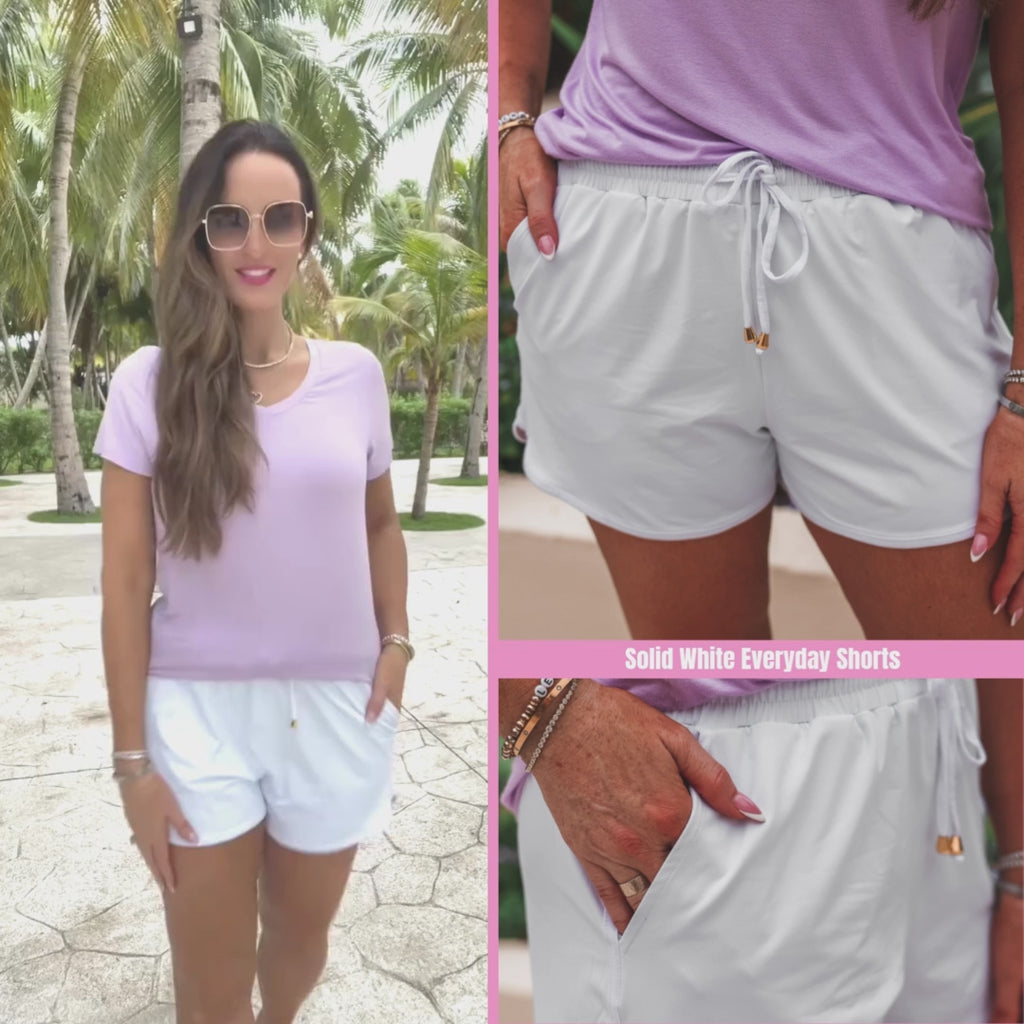 White mid-rise everyday shorts with a relaxed fit, tie waist drawstring, and side pockets, styled for effortless spring and summer looks.