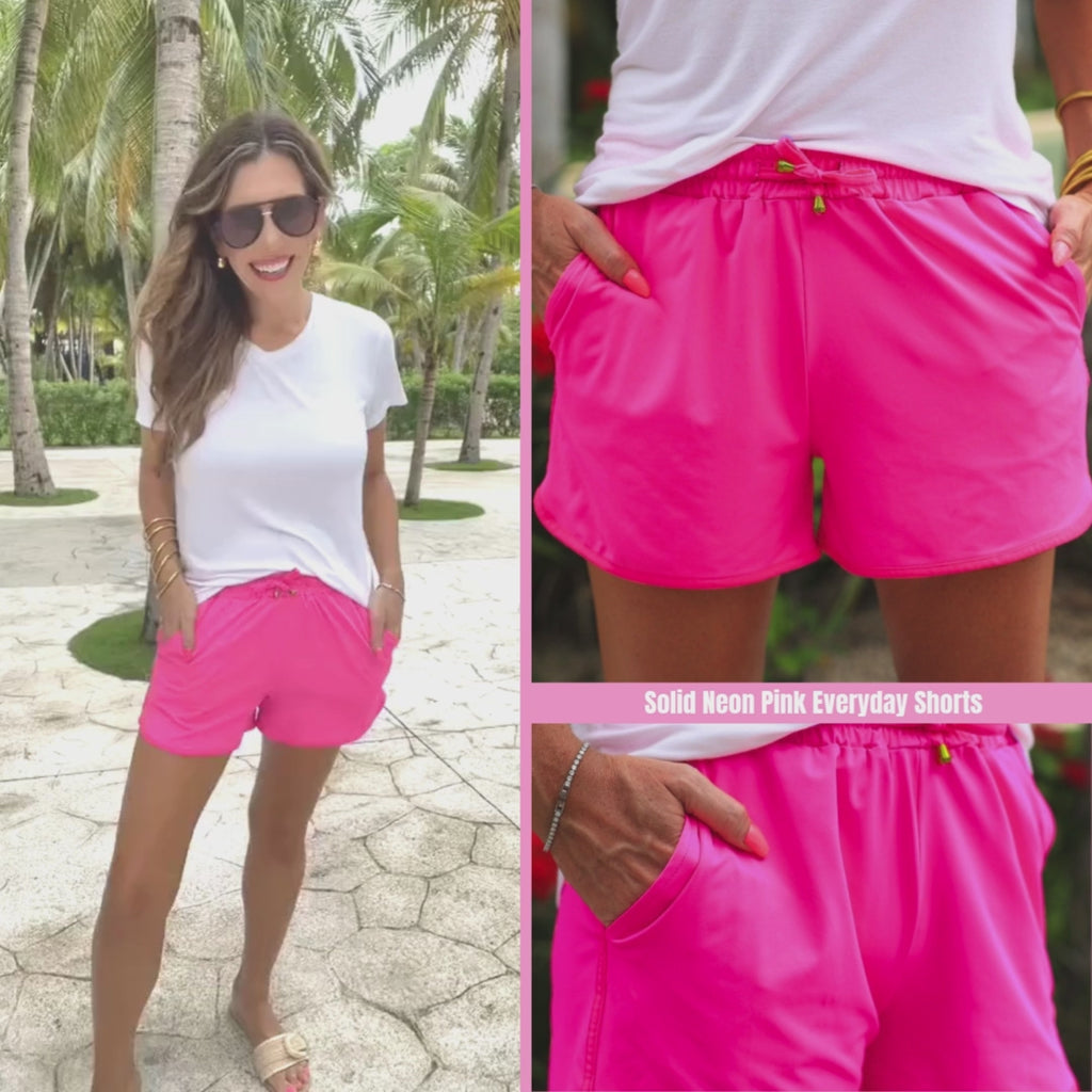 Neon pink mid-rise everyday shorts with a relaxed fit, adjustable drawstring waist, and side pockets, perfect for casual warm-weather outfits.