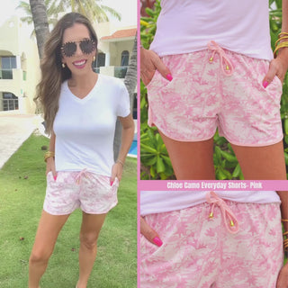 Pink camo printed mid-rise everyday shorts with a relaxed fit, drawstring tie waist, and side pockets, styled for casual spring and summer wear.