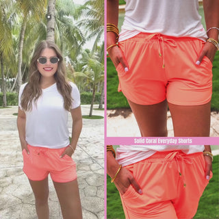 Neon coral mid-rise everyday shorts with a relaxed fit, drawstring tie waist, and side pockets, styled for casual spring and summer wear.