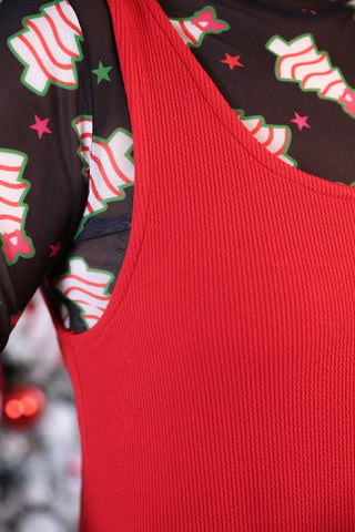 Close-up of a Cozy red ribbed jumper dress layered with a black christmas mesh top, perfect comfy mom style.