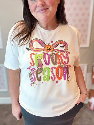 Person wearing a white t-shirt with 'Spooky Season' design in a casual setting.