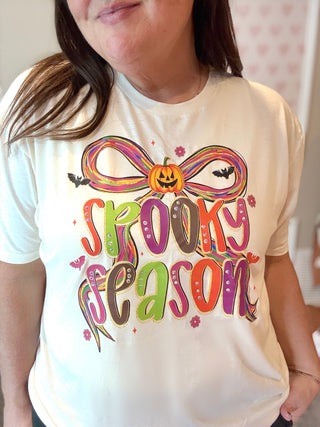 Person wearing a white t-shirt with 'Spooky Season' design.